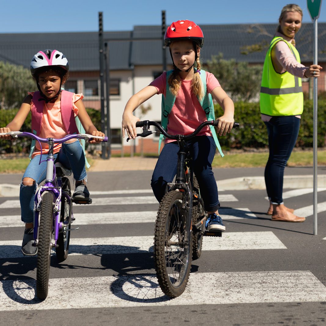 deux enfants apprenant à faire du vélo à l'école